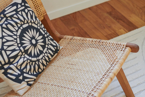 fauteuil lounge en cannage avec coussin beige noir tapis dans home staging réalisé par AntePostea à Reze pres de Nantes