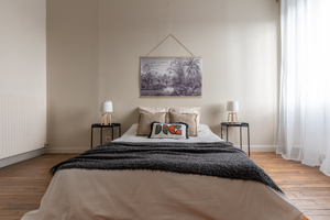 Apres home staging chambre avec lit plaid gris table de chevet lampe coussins deco murale