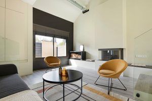 Salon avec cheminée meublé pour la vente avec tapis fauteuil jaune table basse ronde à Nantes