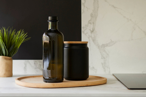 Plateau avec pot et bouteille dans cuisine avec marbre blanc noir