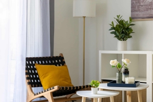 Fauteuil lounge noir et bois avec coussin table gigognes tapis après home staging à Nantes
